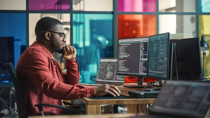 Male Senior Software Developer Writing Code On Desktop Computer With Two Displays Setup in Stylish...