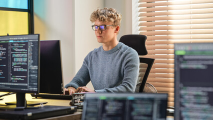 Male Software Engineer Coding On Desktop Computer in Creative Office Space. Young Caucasian Man...