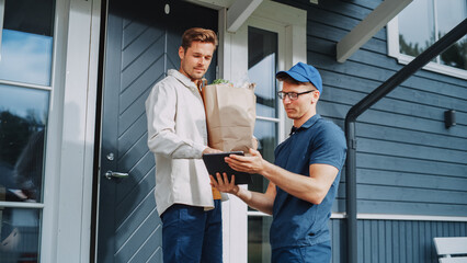 Grocery Delivery Company Employee Bringing a Bag Full of Fresh Vegetables and Other Food Items to a...