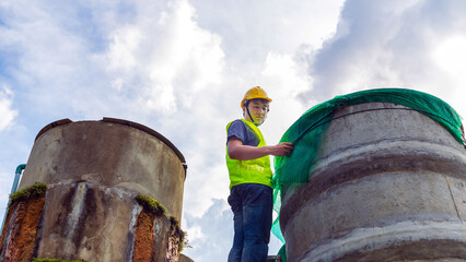 engineer controlling the quality of water Stand on the risky stairs at high places operating...