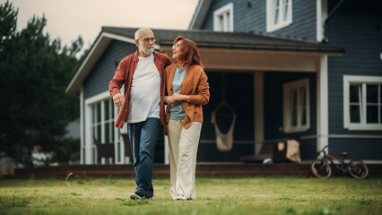Portrait of a Healthy Senior Couple Walking Outdoors Their Residential Area Home, Embracing Each...