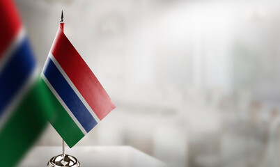 Small flags of the Gambia on an abstract blurry background