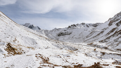 snowy mountain gorge. clouds over the mountains. permafrost
