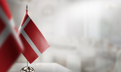 Small flags of the Denmark on an abstract blurry background