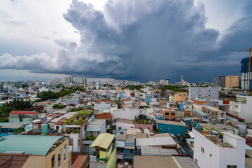 HO CHI MINH, VIETNAM - December 3, 2022: Slum wooden house on the Saigon river bank, in front of modern buildings in ho chi minh city. View to district 1, see Bitexco tower, Landmark 81.