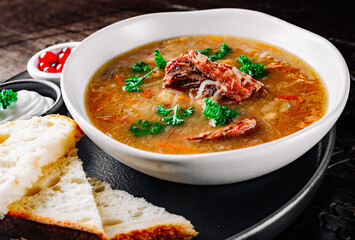 vegetables soup with meat in white bowl on table
