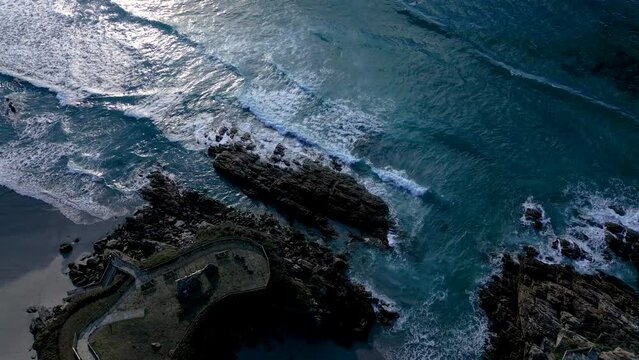 Sea Waves Splashing On Rocky Coastal Park Near Caion Beach In A Coruna, Spain. aerial topdown
