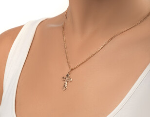 isolated on white background jewelry silver cross on a golden chain around the neck of a model...