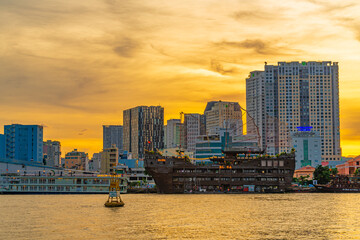 Obraz premium Ho Chi Minh City skyline and the Saigon River at sunset. Amazing colorful view of skyscraper and other modern buildings. Travel concept