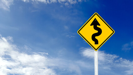 Yellow warn sign with switchback arrow starting from the left on blue sky background