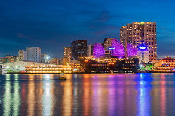 Obraz premium Ho Chi Minh City skyline and the Saigon River at night. Amazing colorful view of skyscraper and other modern buildings. Travel concept
