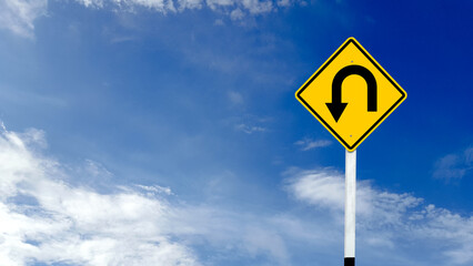 Yellow warn sign with left u turn arrow on blue sky background