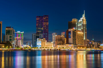 Obraz premium Ho Chi Minh City skyline and the Saigon River at night. Amazing colorful view of skyscraper and other modern buildings. Travel concept