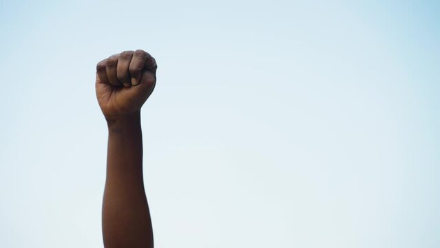 Concept of black history month celebration or activist Hand rising against sky during march