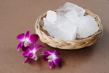 Crystal clear alum stones or Potassium alum on basket, decorated with flowers. Useful for beauty...