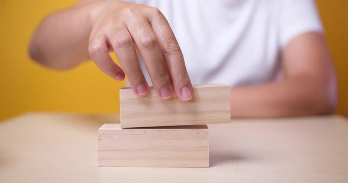 Business growth, building success, ladder career path foundation concept, Hand arranging wood block stacking as step stair. Copy space. Slow motion
