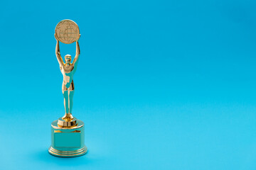 Golden statuette of a man on blue background