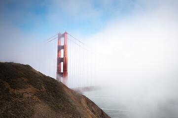 Detail of the big red Golden Gate Bridge hidden by the dense fog