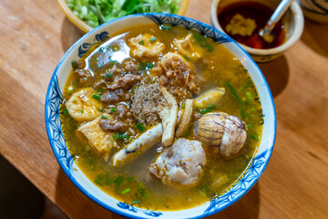 Vietnam traditional street food bun rieu cua crab rice noodle soup bowl with pork foot, blood cake and tofu