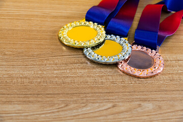 Three medals on wooden table