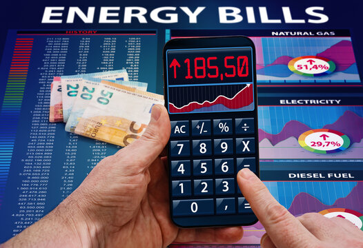 Man Hands With Cost Calculator Application About Electric Power, Gas And Fuel Costs In The Household. Hand With Phone Calculator App Analyzing Energy Bill Expenses, Concept High Cost Of Energy Bill