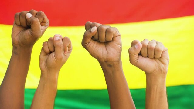 Concept of unity in diversity or equality showing by Group of fist hands rising against the Black history flag