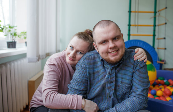 caring mom hugs a child diagnosed with autism in a rehabilitation center.