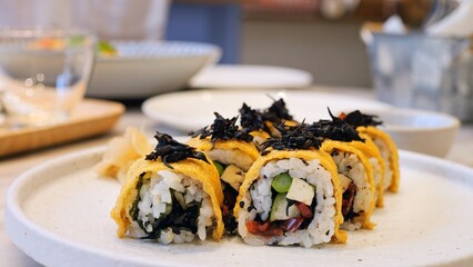 Cinematic footage of rolls on a plate in a Japanese restaurant. Gourmet Japanese dishes with fresh seafood and vegetables with soy sauce and wasabi to give a more pronounced taste to the rolls.