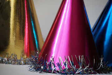 Colorful party hats. Celebration or party background. Golden, magenta, blue party hats.
