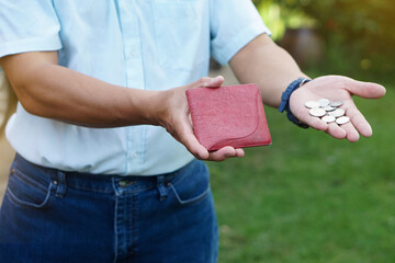 Closeup hand holds Thai baht coins and empty wallet.  Concept, no money, economic crisis. Financial...