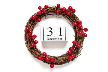 Christmas wreath decorated with red berries, wooden calendar date 31 December isolated on white background Concept of Christmas preparation, atmosphere Wishes card Hand made Christmas wreath Flat lay - 555661397