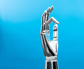 Robot hand making ok gesture on blue background