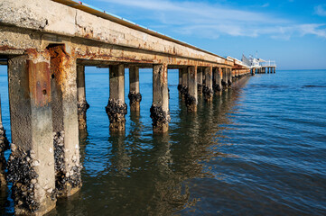 Concrete pier leading to a restaurant above seashore