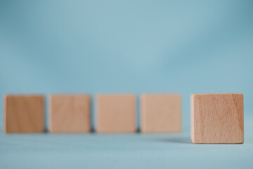 Business design,financial,education,abstract,logo,text concept.,Focus on last blank wooden cubes in row over blue background.,Banner,wallpaper,background idea.