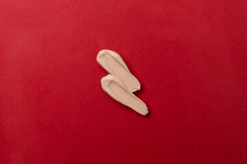 Foundation smudges on color background, top view