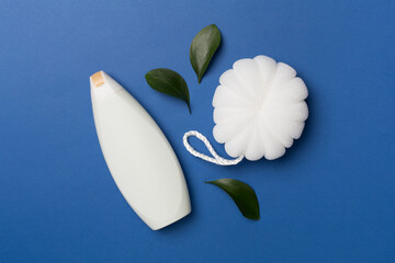 Shower gel with washcloth on color background, top view