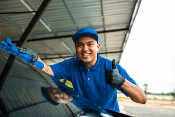 Man worker washing car service with micro fiber. Car wash cleaning wipe station. Employees clean a vehicle professionally detailing.