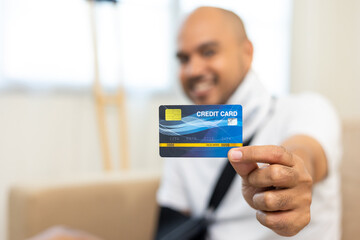 Happy man using credit card pay medical expenses from accident fracture broken bone injury with leg splints in cast neck splints collar sling support arm. Social security and health insurance.