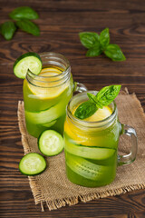 Fresh cucumber lemonade with basil and lemon in a glass mug.