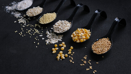 Colección de cucharas con diferentes cereales y semillas en fondo negro. Dark food