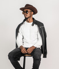 An african man white blank shirt sitting on the top of a chair with white background
