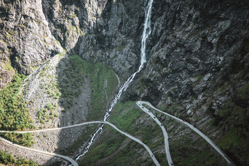 Fototapeta na wymiar Waterfall at the trollstigen road in Norway with some mountains.