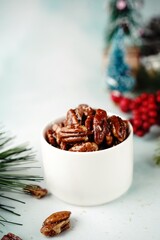 Candied pecans on festive holiday background, selective focus