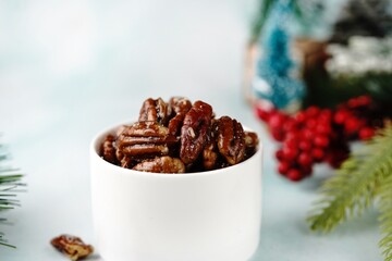 Candied pecans on festive holiday background, selective focus