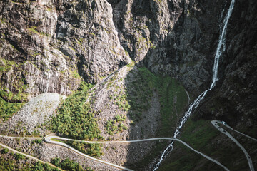 Waterfall at the trollstigen road in Norway with some mountains.