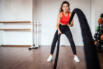 A sports person is engaged in his health. A female exercise trainer does a workout at a fitness club.