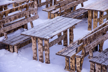 Lunch area with frozen chairs and tables  on a cold cloudy winter day.
