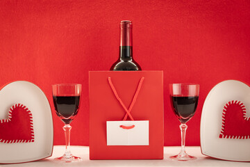 Fond d'écran pour la Saint-Valentin avec un paquet cadeau et du vin rouge. Composition romantique...