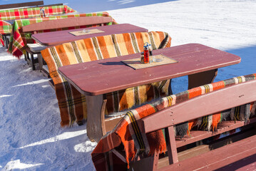 Outdoor restaurant tables in a snowy winter landscape, Pamporovo, Bulgaria.
