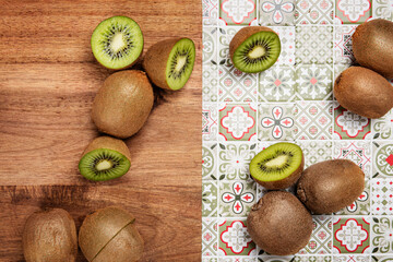 kiwi on wooden table on green patterned tile background
